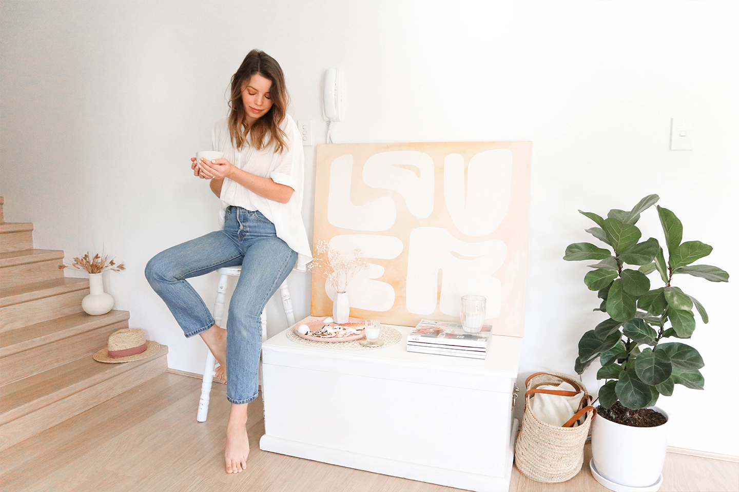 abstract lover artwork on canvas with white chest, fiddle fig, rattan basket and classic jeans and white tshirt outfit